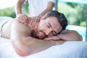 Man receiving back massage from massage therapist in spa